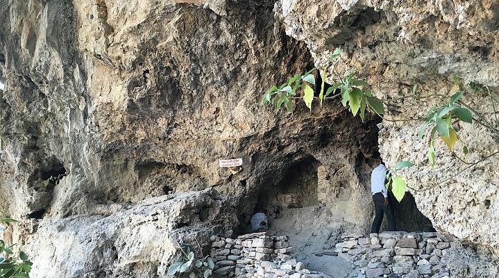 Serene meditation retreat by the river Ganga, featuring tranquil caves and a rocky beach for peaceful reflection and nature immersion. Ideal for quiet, crowd-free relaxation.
